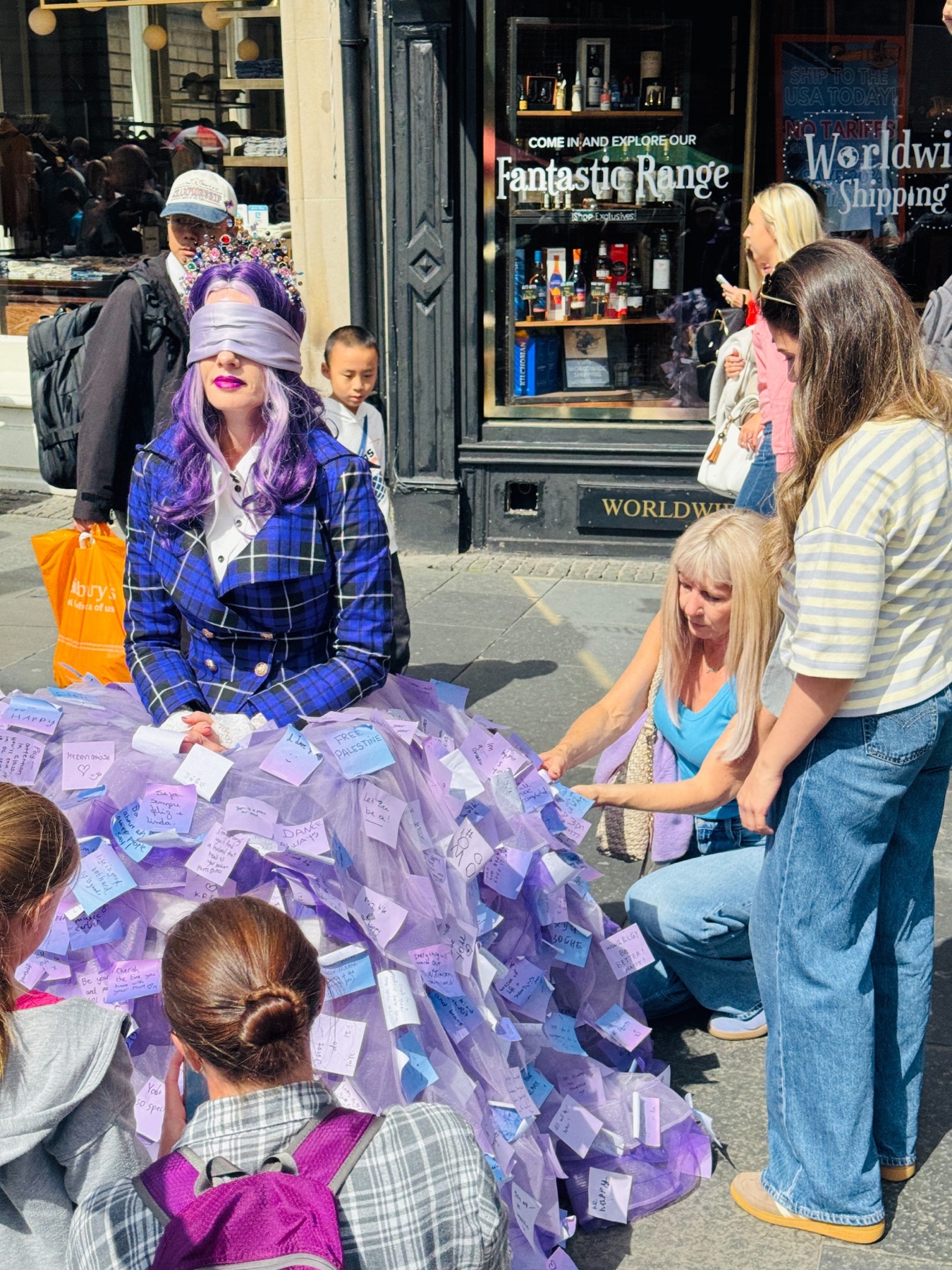 People pausing to read and attach notes to the Purple Threads skirt